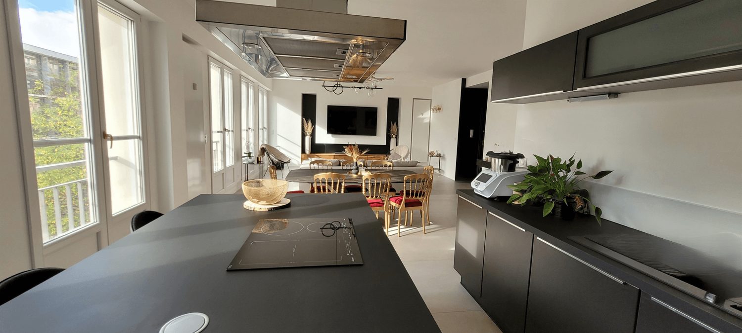 Cuisine équipée — îlot central, plaques à induction et hotte